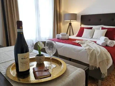 a bottle of wine on a table next to a bed at Rome in Style St Peter in Rome