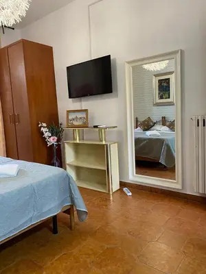 a bedroom with a mirror and a bed and a television at Milazzo Luxury Home roma in Rome