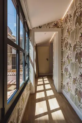 a hallway with windows and a wall of wallpaper with flowers at Vicario Suites in Rome