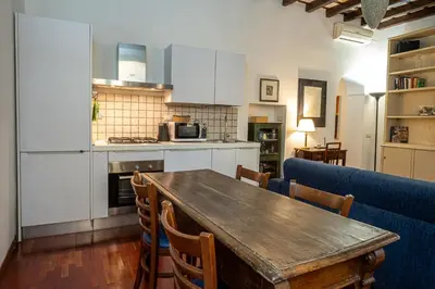a kitchen and dining room with a wooden table and chairs at Appartamento Margherita 2 in Rome