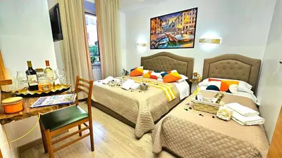 a hotel room with two beds and a table and a desk at A Casa Simpatia in Rome