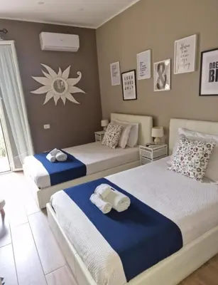 a bedroom with two beds with blue and white sheets at Home K&Y - Aurelio in Rome