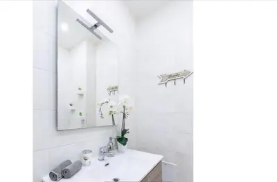 a white bathroom with a sink and a mirror at Home K&Y - Aurelio in Rome