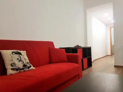 a red couch with a pillow on it in a living room at Trastevere Sweet Home in Rome