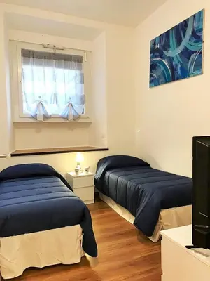 a bedroom with two beds and a tv and a window at Trastevere Sweet Home in Rome