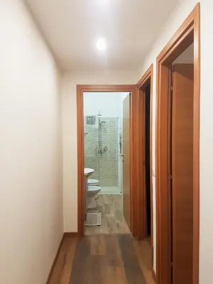 a corridor of a bathroom with a toilet and a sink at Trastevere Sweet Home in Rome