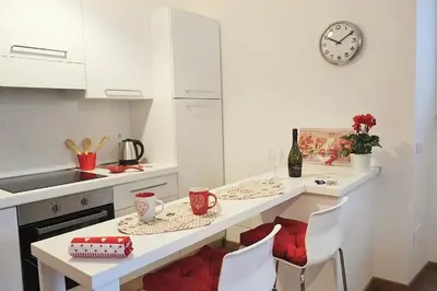 a kitchen with a table with chairs and a clock on the wall at Trastevere Sweet Home in Rome