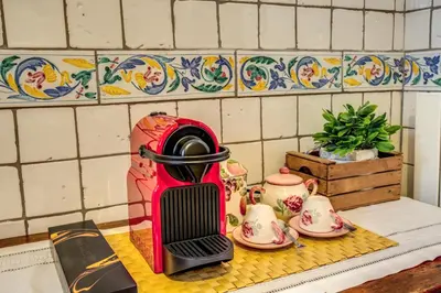 a red toaster sitting on a kitchen counter with tea sets at FRESH HOUSE MONTI in Rome