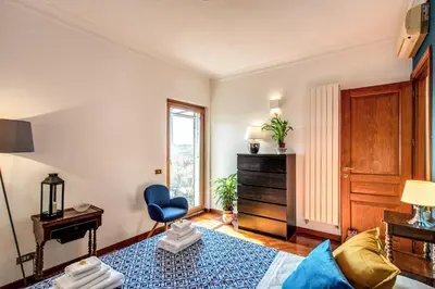a living room with a blue chair and a window at FRESH HOUSE MONTI in Rome