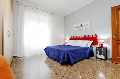 a bedroom with a bed with a blue blanket and a window at Martino Delightful Apartment in Rome