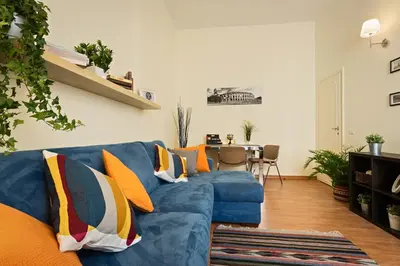 a living room with a blue couch with colorful pillows at St. Joseph Apartment 47 in Rome