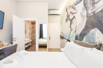 a bedroom with a white bed and a painting on the wall at B-STAY Via Milano 52 in Rome