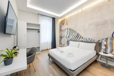 a bedroom with a bed and a desk and a tv at B-STAY Via Milano 52 in Rome