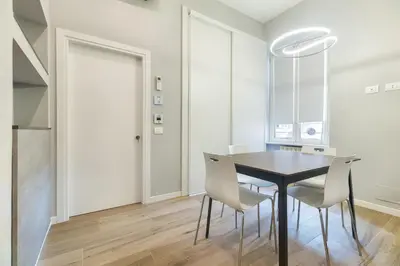 a dining room with a black table and white chairs at B-STAY Via Milano 52 in Rome