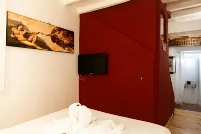 a bedroom with a red door and a tv on the wall at Il Rifugio di Trastevere in Rome