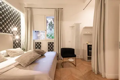 a bedroom with a bed and a chair and a window at EBL LUXURY HOME in Rome