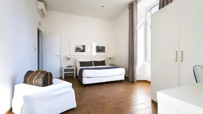 a white bedroom with a bed and a table at Rest Guesthouse in Rome