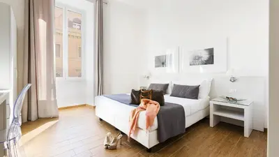 a white bedroom with a bed and a table at Rest Guesthouse in Rome