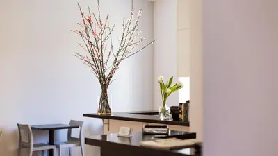 a dining room with a table with two vases with flowers at Rest Guesthouse in Rome
