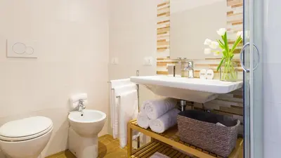 a white bathroom with a toilet and a sink at Rest Guesthouse in Rome
