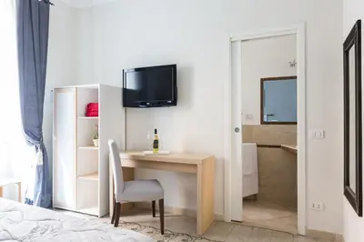 a bedroom with a desk and a tv on a wall at B&B Calamatta in Rome