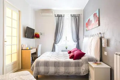 a bedroom with a bed and a desk and a window at B&B Calamatta in Rome