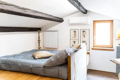 a bed in a room with white walls and a window at Arc Trilussa 44 in Rome