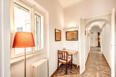 a hallway with a table and a lamp and a window at Cavour Attic with terrace in Rome