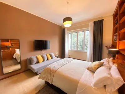 a bedroom with a large bed and a couch at DOWNTOWN SRL - Borghese Green in Rome