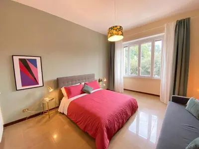 a bedroom with a pink bed and a window at DOWNTOWN SRL - Borghese Green in Rome