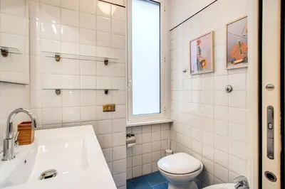 a bathroom with a sink and a toilet and a window at DOWNTOWN SRL - Borghese Green in Rome