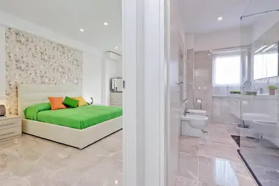 a bedroom with a green bed and a bathroom at Maison Roberta San Peter in Rome