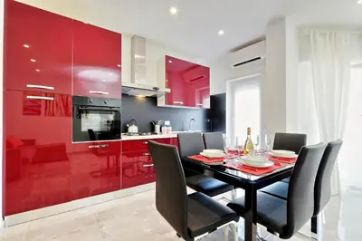 a kitchen with a dining table and red cabinets at Maison Roberta San Peter in Rome