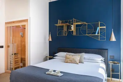 a bedroom with a blue wall with a bed at ROMAC Trinity - 3bdr apartment with Sauna & Jacuzzi in Campo de Fiori in Rome