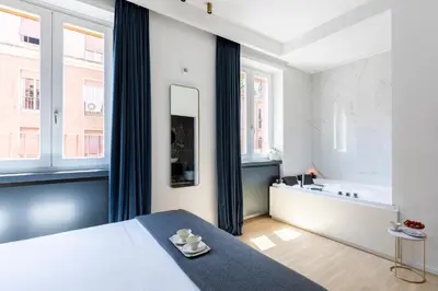 a bedroom with a bed and two windows at ROMAC Trinity - 3bdr apartment with Sauna & Jacuzzi in Campo de Fiori in Rome