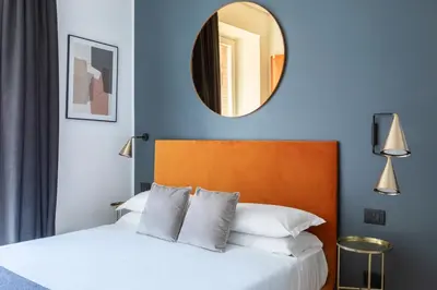 a bedroom with a bed with a mirror on the wall at ROMAC Trinity - 3bdr apartment with Sauna & Jacuzzi in Campo de Fiori in Rome