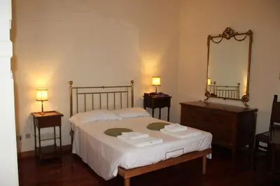 a bedroom with a bed with two night stands and a mirror at Colosseum New Charming Apartment in Rome