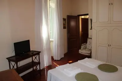 a bedroom with a bed and a desk and a television at Colosseum New Charming Apartment in Rome