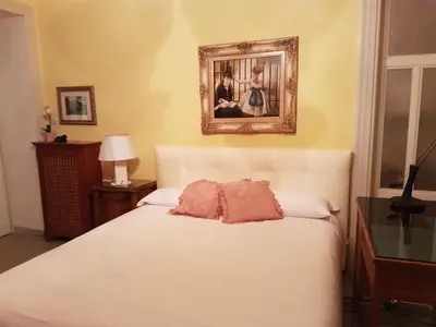 a bedroom with a white bed with a picture on the wall at Luxury San Giovanni in Rome