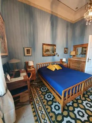 a bedroom with a large blue bed and a table at Luxury San Giovanni in Rome