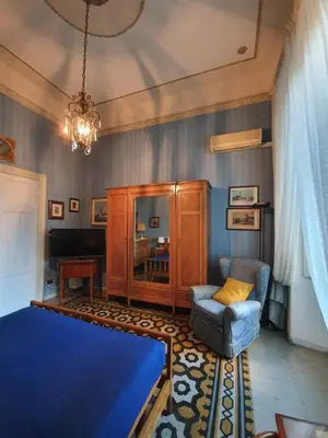 a bedroom with a bed and a chair and a chandelier at Luxury San Giovanni in Rome