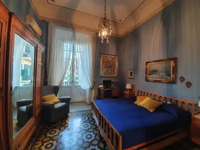 a bedroom with a blue bed and a chair at Luxury San Giovanni in Rome