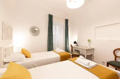 a hotel room with three beds and a desk at Leonardo Suite Pantheon in Rome