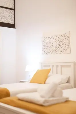 a white bedroom with a bed with a table at Leonardo Suite Pantheon in Rome