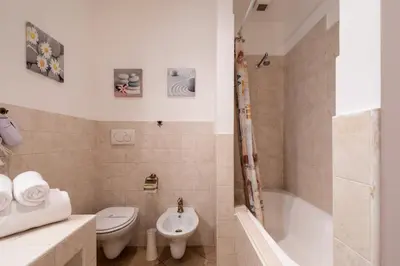 a bathroom with a toilet and a tub and a sink at Trastevere In Love in Rome