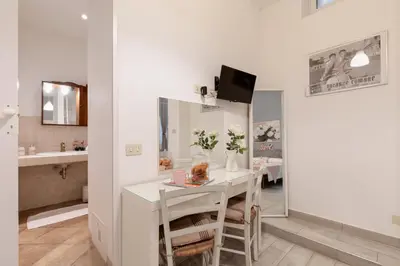 a white dining room with a table and a bathroom at Trastevere In Love in Rome
