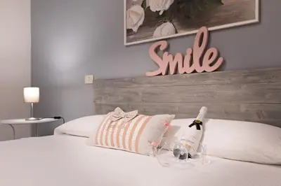 a bottle of champagne on a bed with a smile sign at Trastevere In Love in Rome