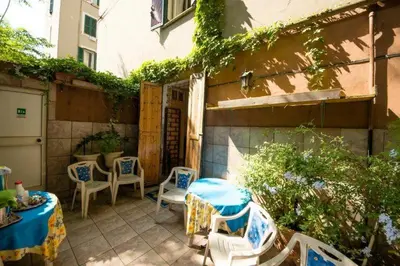 a patio with a table and chairs and a building at SUNSHINE HOSTEL in Rome