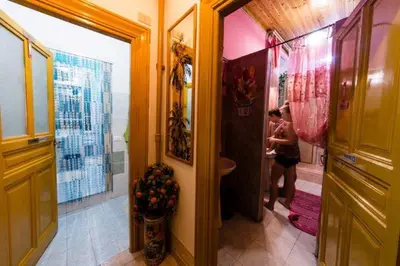 a woman is standing in a bathroom with a sink at SUNSHINE HOSTEL in Rome