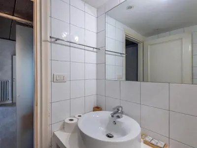 a white bathroom with a sink and a mirror at Apartment Antico Balcone by Interhome in Rome